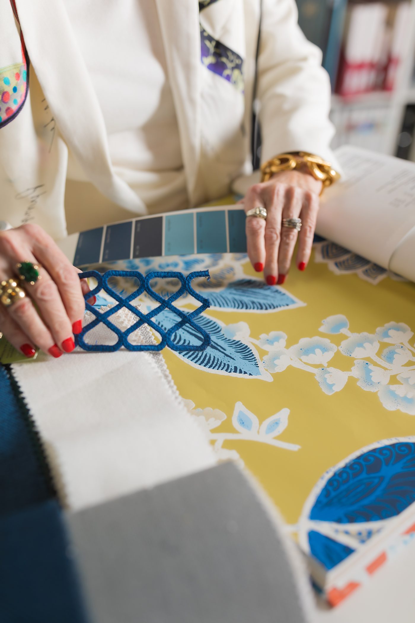 Designer selecting fabrics, trims, and a blue paint palette for a custom order at Kathy Adams